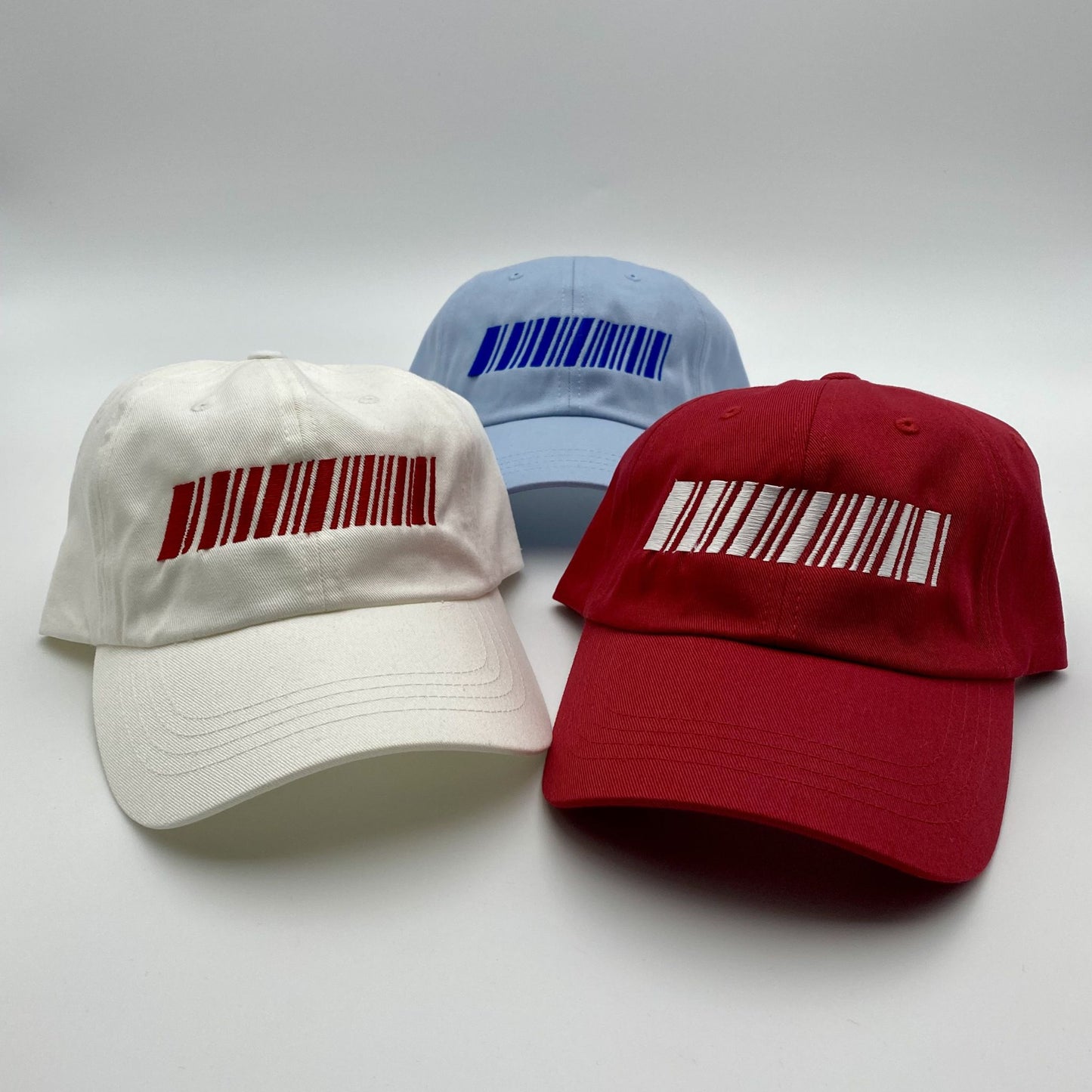 Three racing caps with barcode designs on a white background