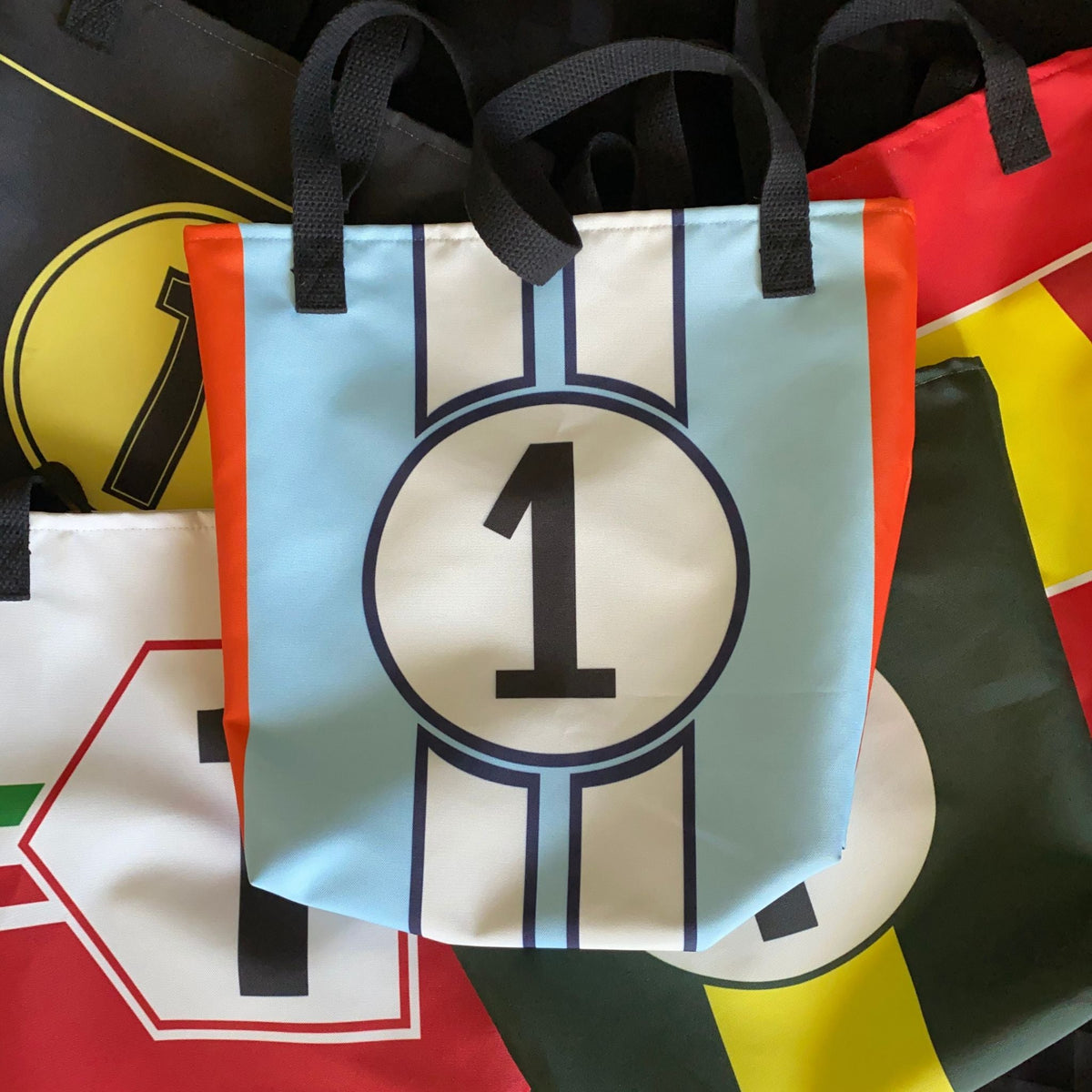 Tote bags in bright racing liveries with a number "1"