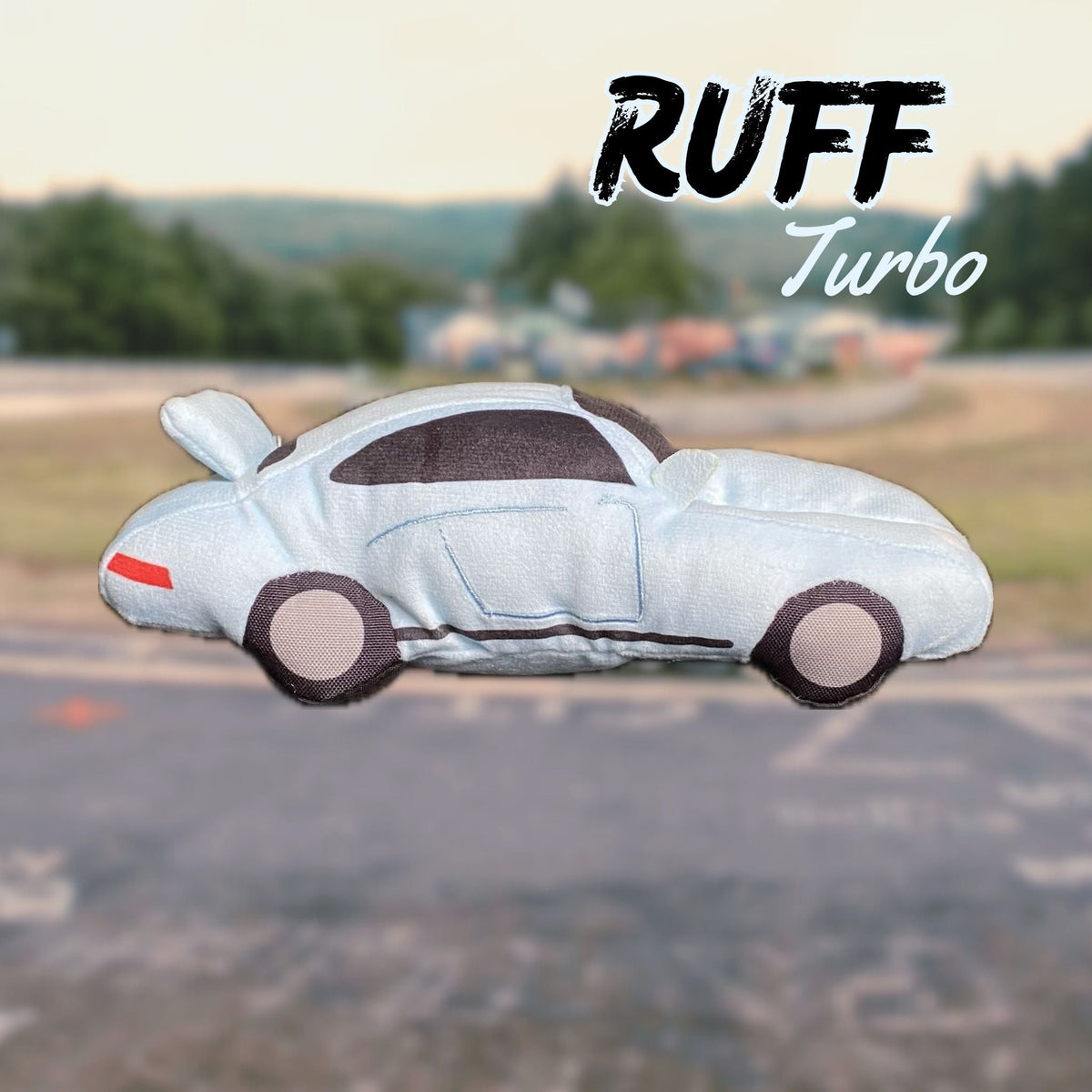 Dog toy shaped like a sports car with "Ruff Turbo" branding on a blurred race track background