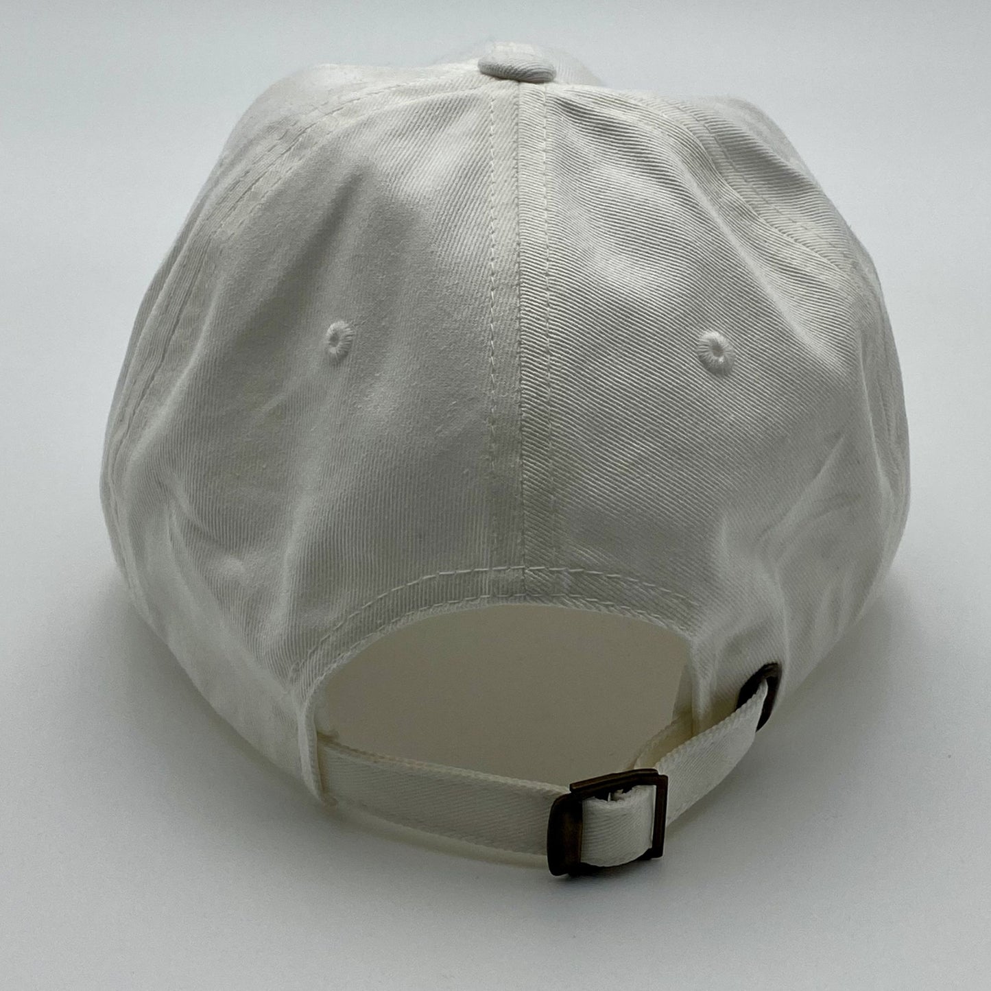 Back view of a white cap with an adjustable strap on a white background