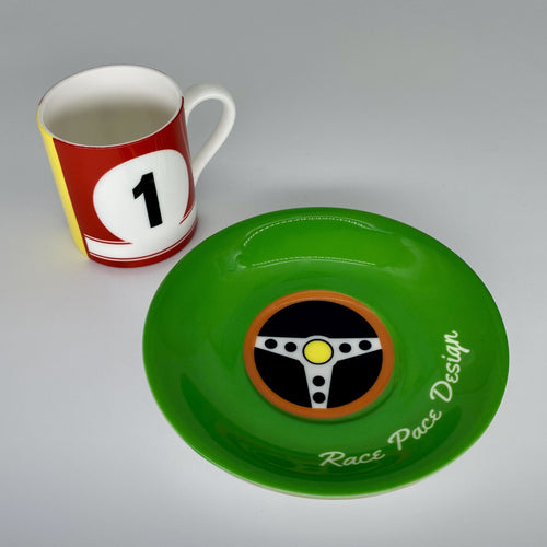 Green plate with a steering wheel design and a red and white mug with number 1 on a gray background