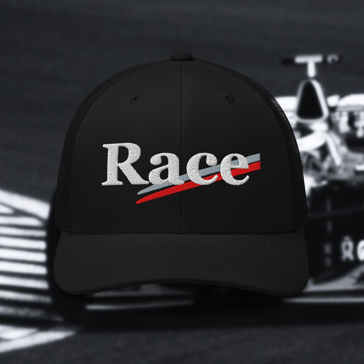 Black cap with 'Race' text in white with silver and red stripes on a blurred race car background