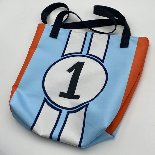 Blue tote bag with number 1 design, white stripes and orange accents on a white background