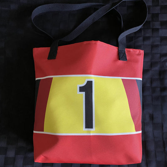 Red tote bag with a black, red and yellow stripe with a black number 1 on a textured black background