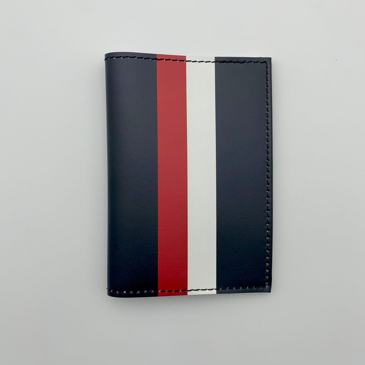 Black passport cover with red, and white stripes on a white background