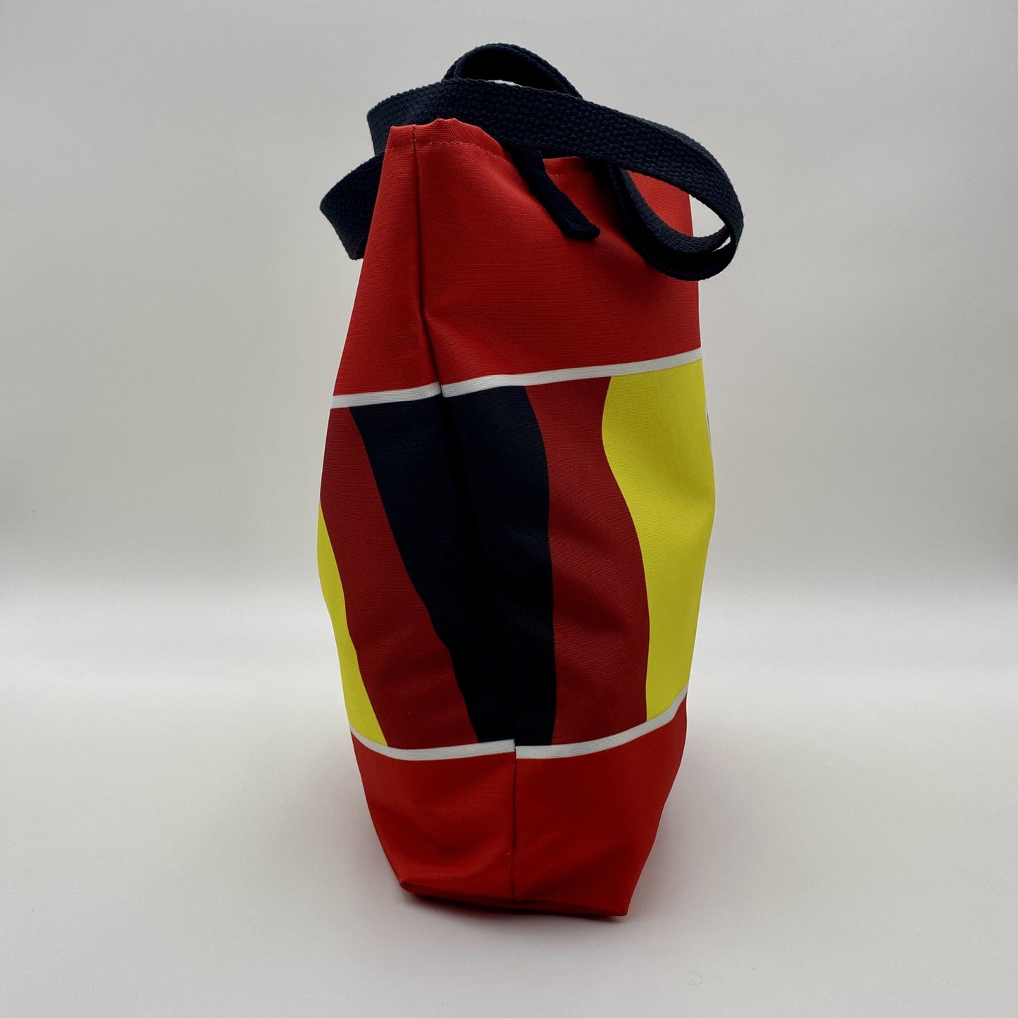 Colorful bag with red, yellow, and black design on a white background