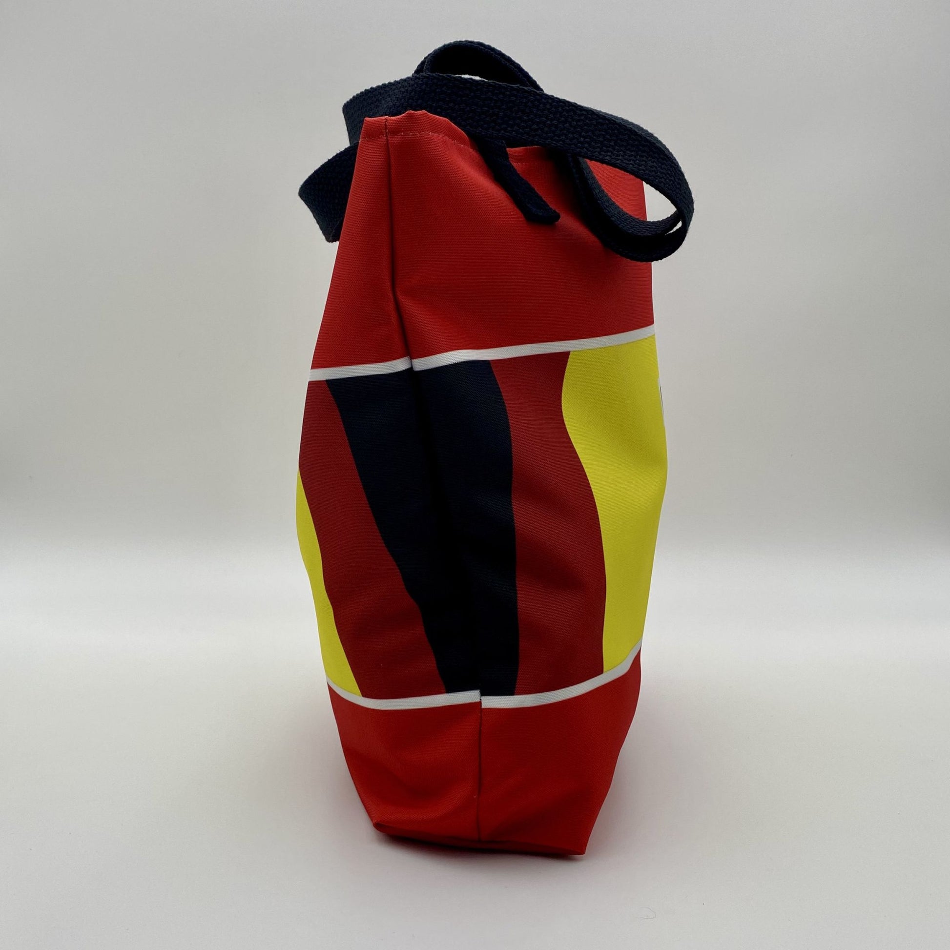 Colorful bag with red, yellow, and black design on a white background