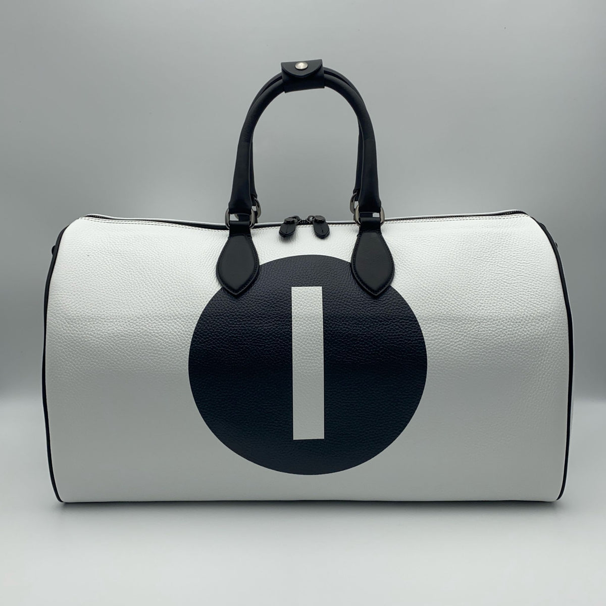 White leather duffle bag with a black circle and white number '1' on a white background