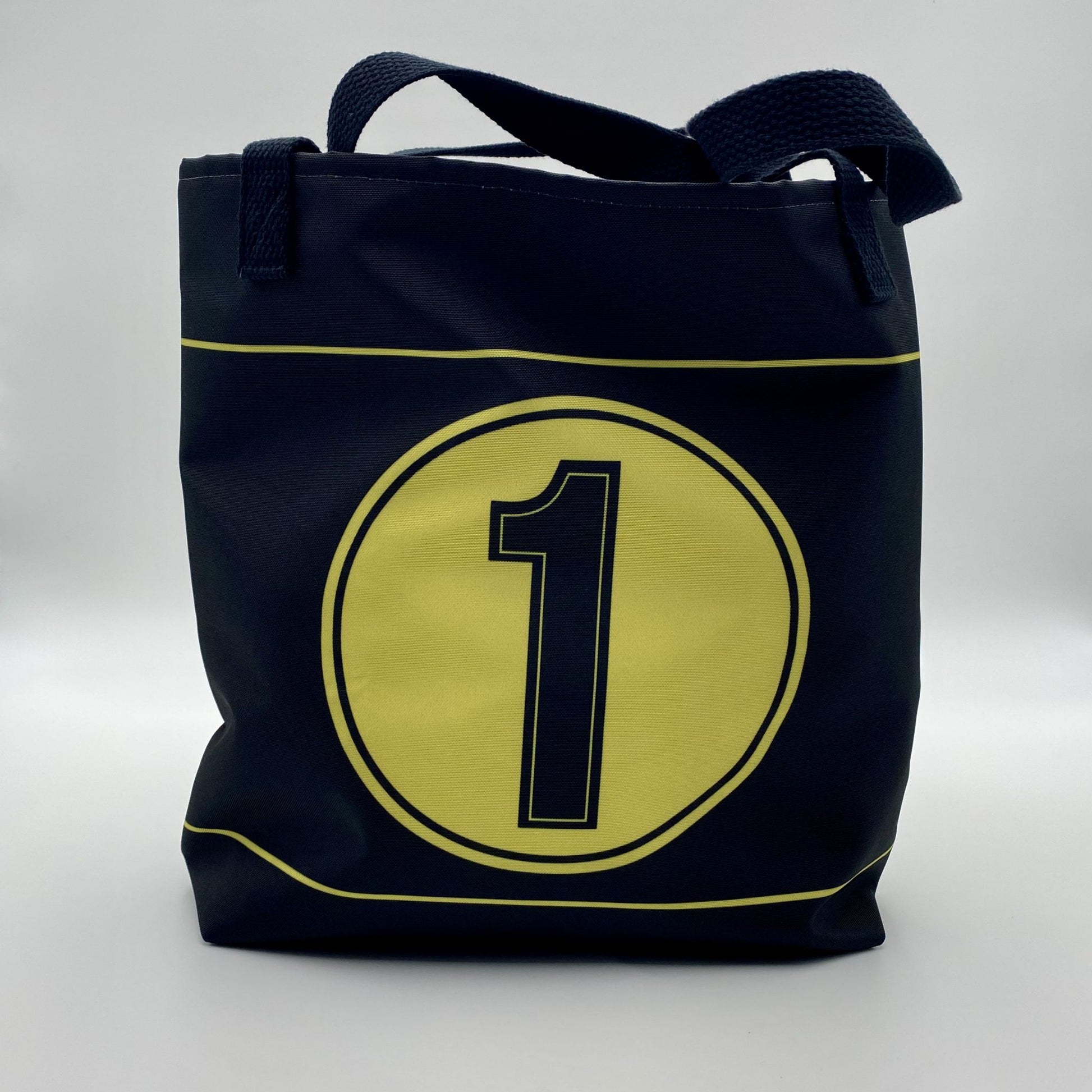 Black tote bag with a yellow circle and number one on a white background