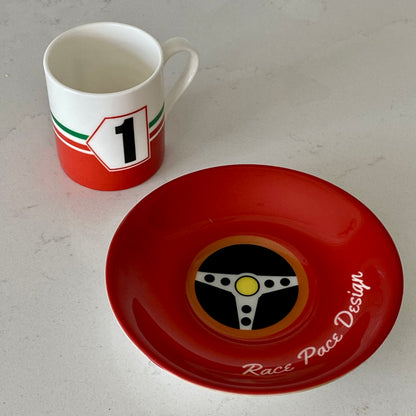 Red and white espresso cup with number 1 and Italian flag next to a red saucer on a white surface